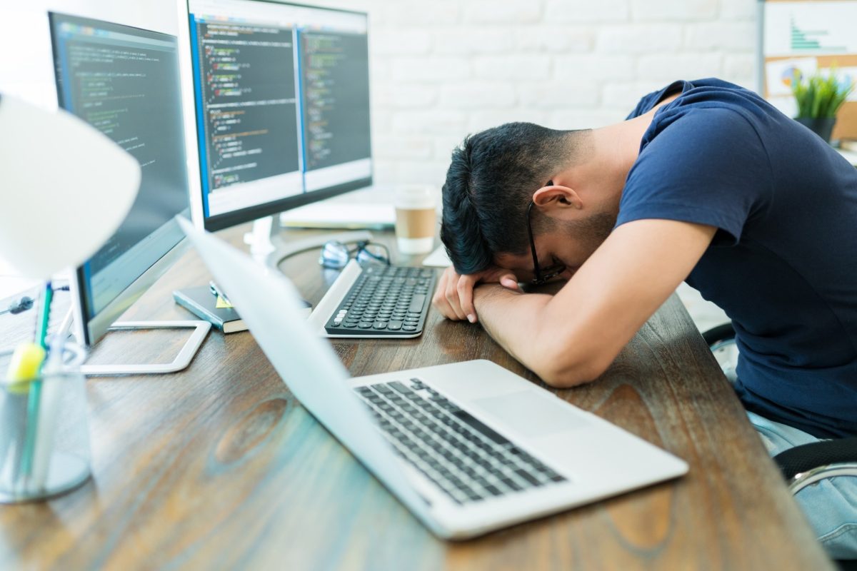 The morning after an incident: someone slumped over a desk in front of screens, the human cost of a bad year.